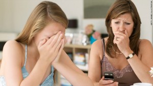 A girl crying while an older woman reads something on her phone looking upset.