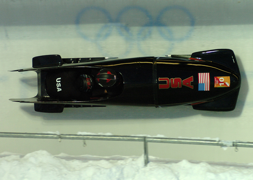 A two-person team in a bobsled race. The bobsled has an aerodynamic design and smooth runners so it can go as fast as possible.