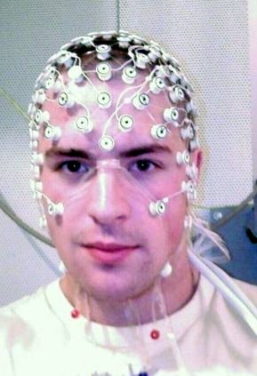 This picture shows a human participant with electrodes placed on his head and face.
