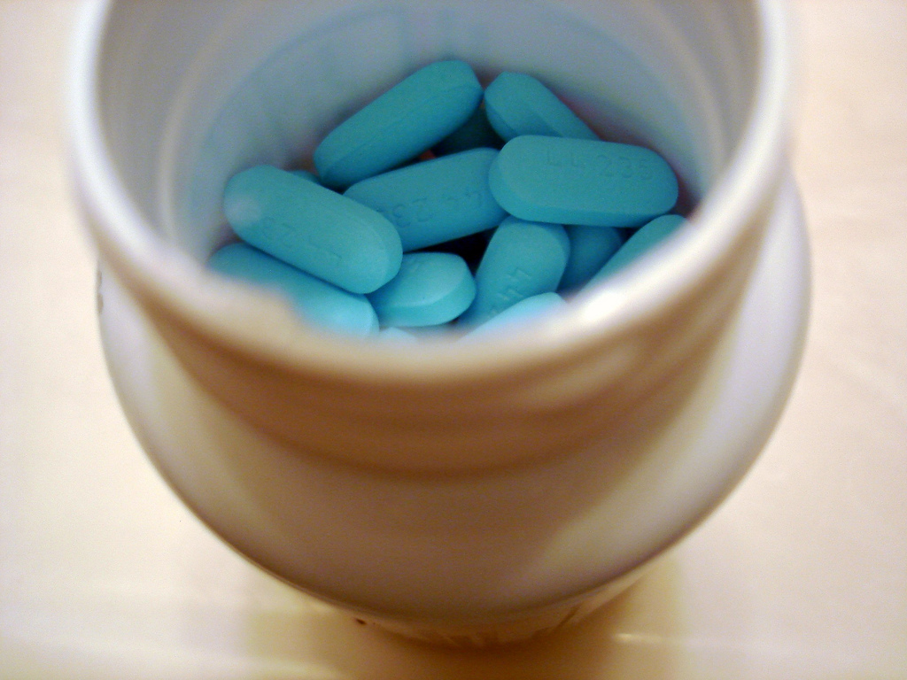 This picture shows blue pills in a white container.