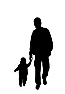 Silhouette of man holding a small child by the hand