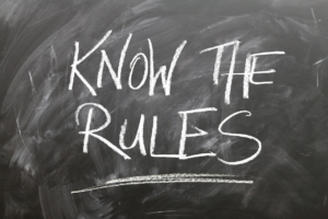 Writing on a blackboard that reads, "Know the rules"