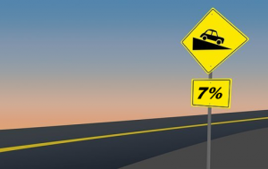 A road sign indicating that the road ahead has a grade of 7 percent.