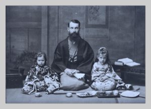 John Cooper Robinson with his young daughters Lucy and Hilde, a photograph by Miyashita Kin. They are seated on the floor in traditional Japanese garb.