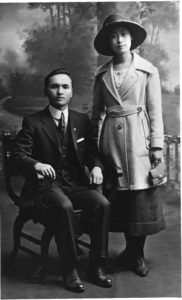 A portrait, dated to 1921, of a standing woman, Hanako Sato, and a seated man, Tsutae Sato. Hanako taught at the Vancouver Japanese Language School on Alexander Street.