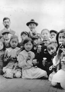 In this photo, a group of ten Language School students enjoy ice cream with their teachers during a picnic outing.