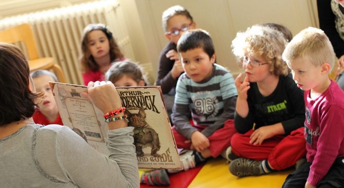 Woman reading book to children