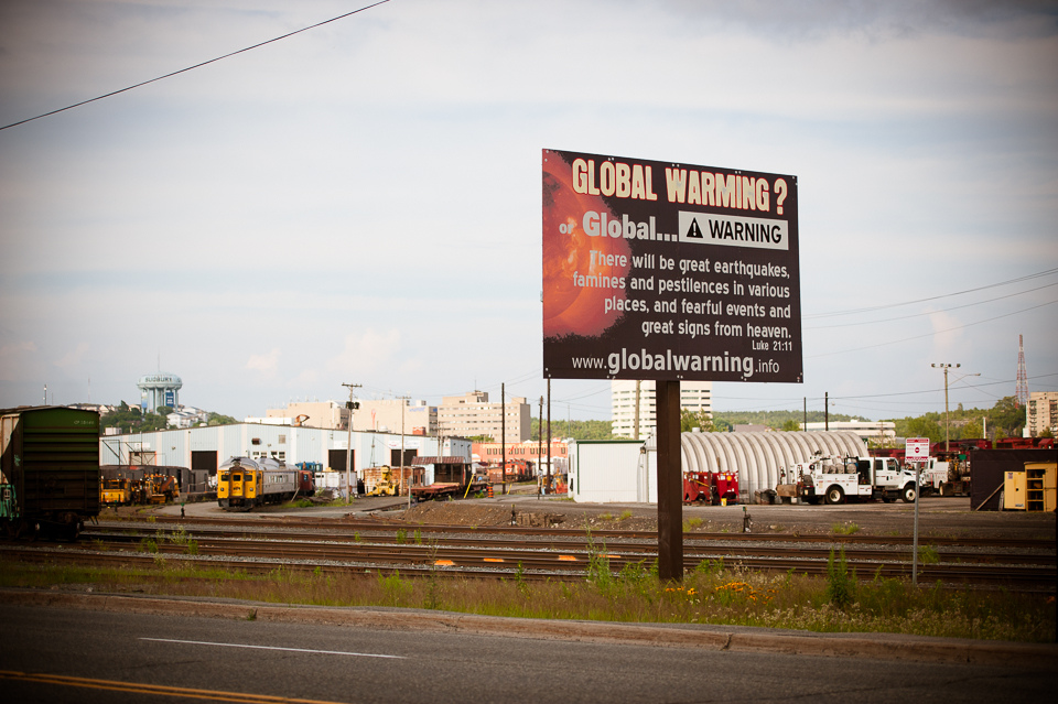 Photographs of a billboard suggesting climate change is a sign from God.