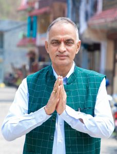 Senior man holding his palms together in the नमस्ते (namaste) greeting gesture outdoors.
