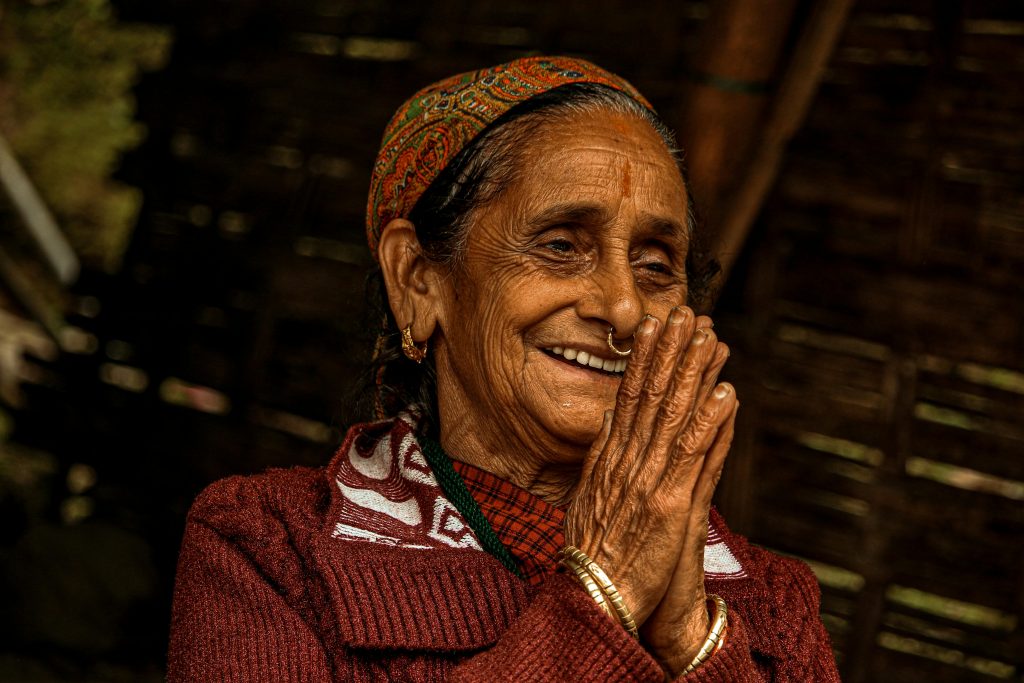 Close-up of an elderly woman with her hands together.