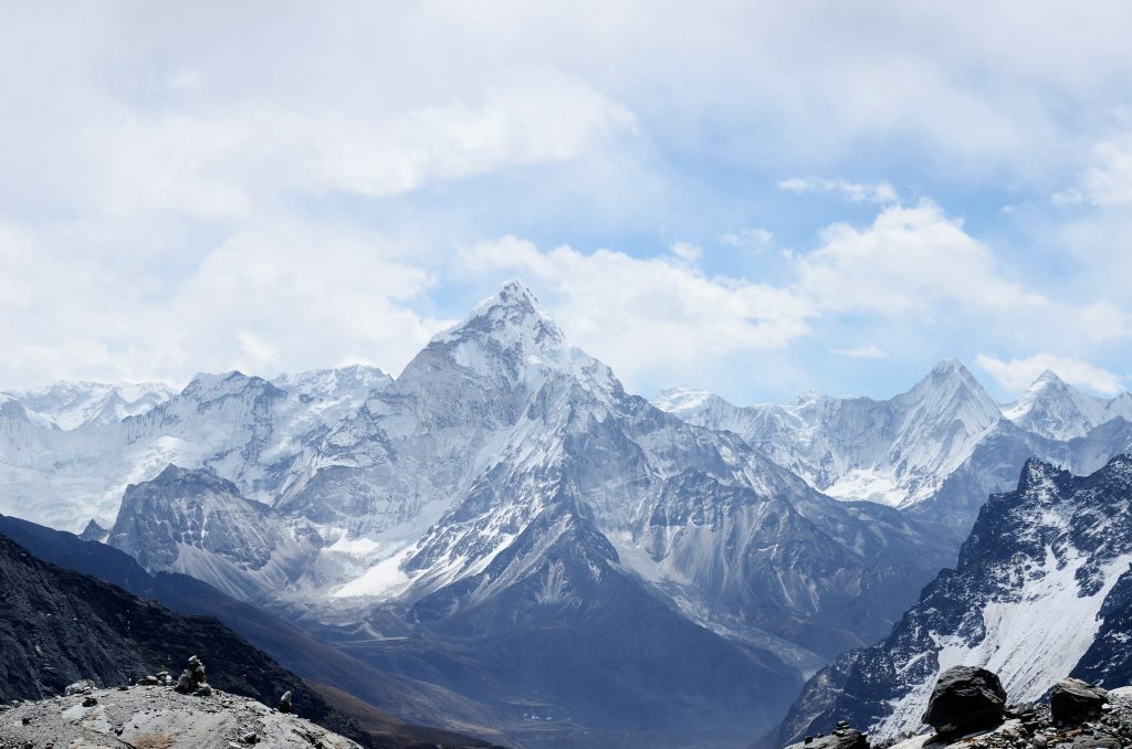 Snow-covered Ama Dablam under blue sky and clouds in Sagarmatha National Park, Nepal.