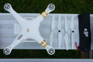 Photo showing the DJI Phantom 3 Professional drone from above with four propellers arranged next to it.