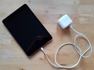 Photo of an iPad with the charging cable attached