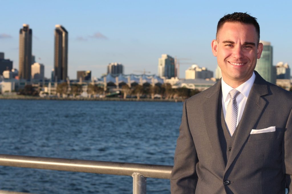 A broker smiling, standing next to a lake