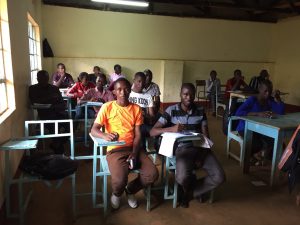 Kenyan students sit at desks in a classroom