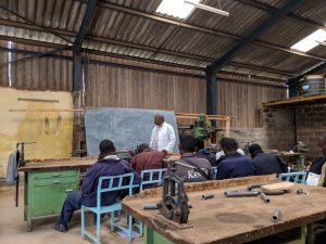 Kenyan TVET instructor teaching students in a workshop