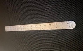 A small, metal ruler measuring up to 6 inches and 15 centimeters.