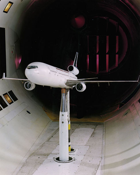 A photograph of a model plane in a wind tunnel.