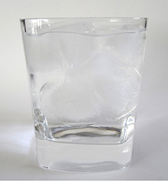 A photo of a glass of ice water filled to the brim.