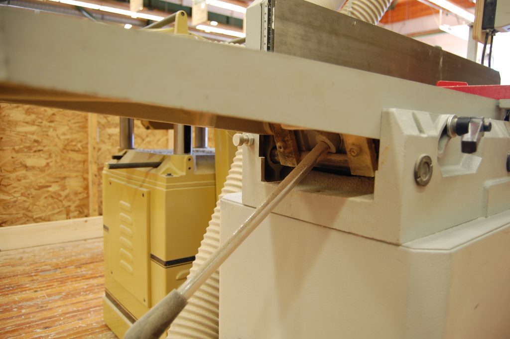 Jointer with pivoting arm table adjustment