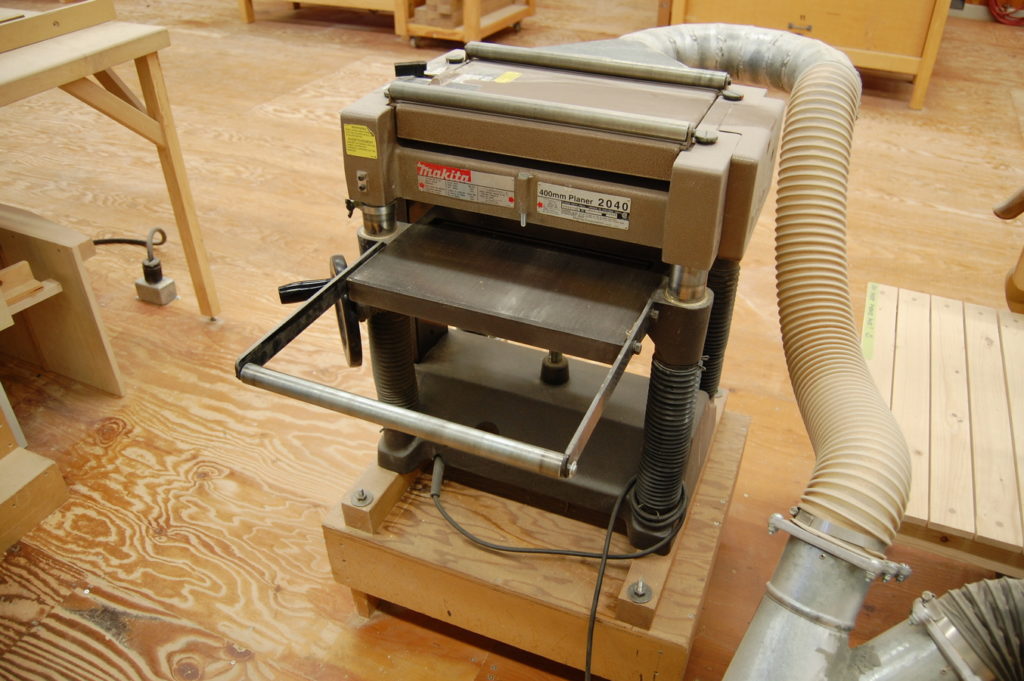 Open roller-type table extension on a planer