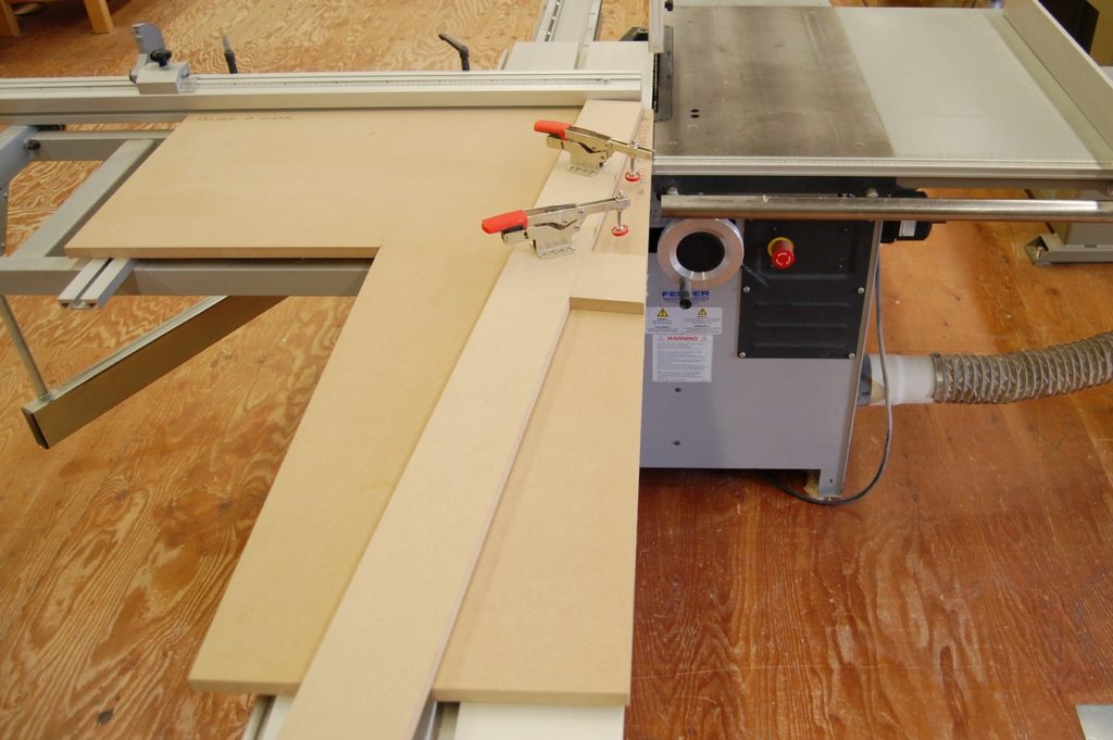 Panel saw zero clearance table, shown with fences and clamps for tapering