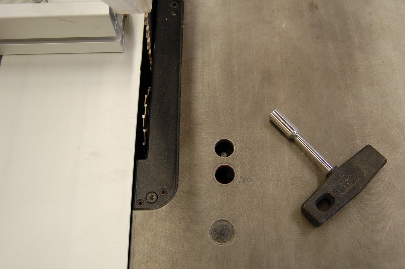 Looking down at the scoring blade adjustment access and wrench