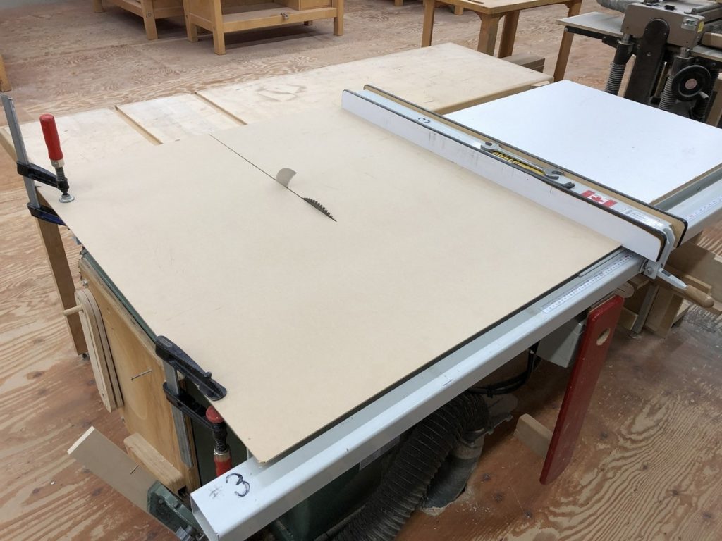 an MDF sub-table on the table saw for ripping thin materials. MDF is run until it covers the saw table, and is then clamped in place.