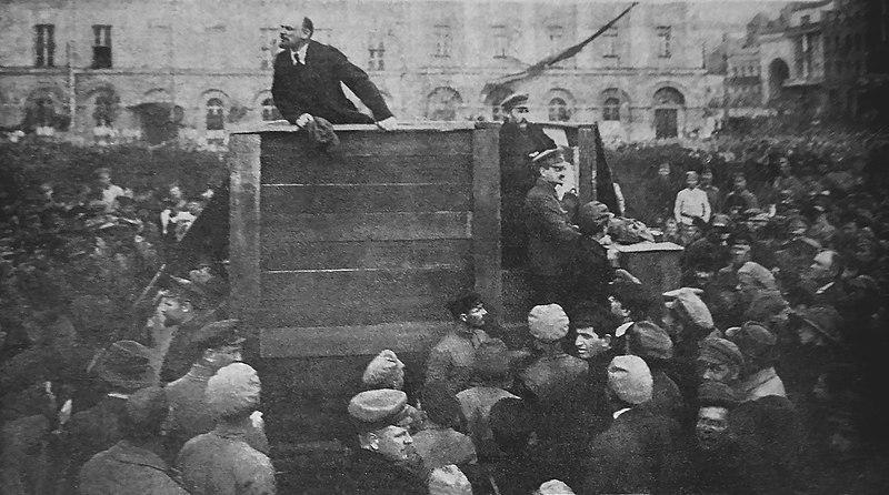 Lenin standing on a platform giving a speech to a crowd in 1920.